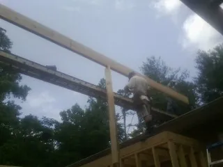 Carpenter setting a ridge beam over a new addition frame — Ice Dam Removal by Roofing Brothers in Frisco