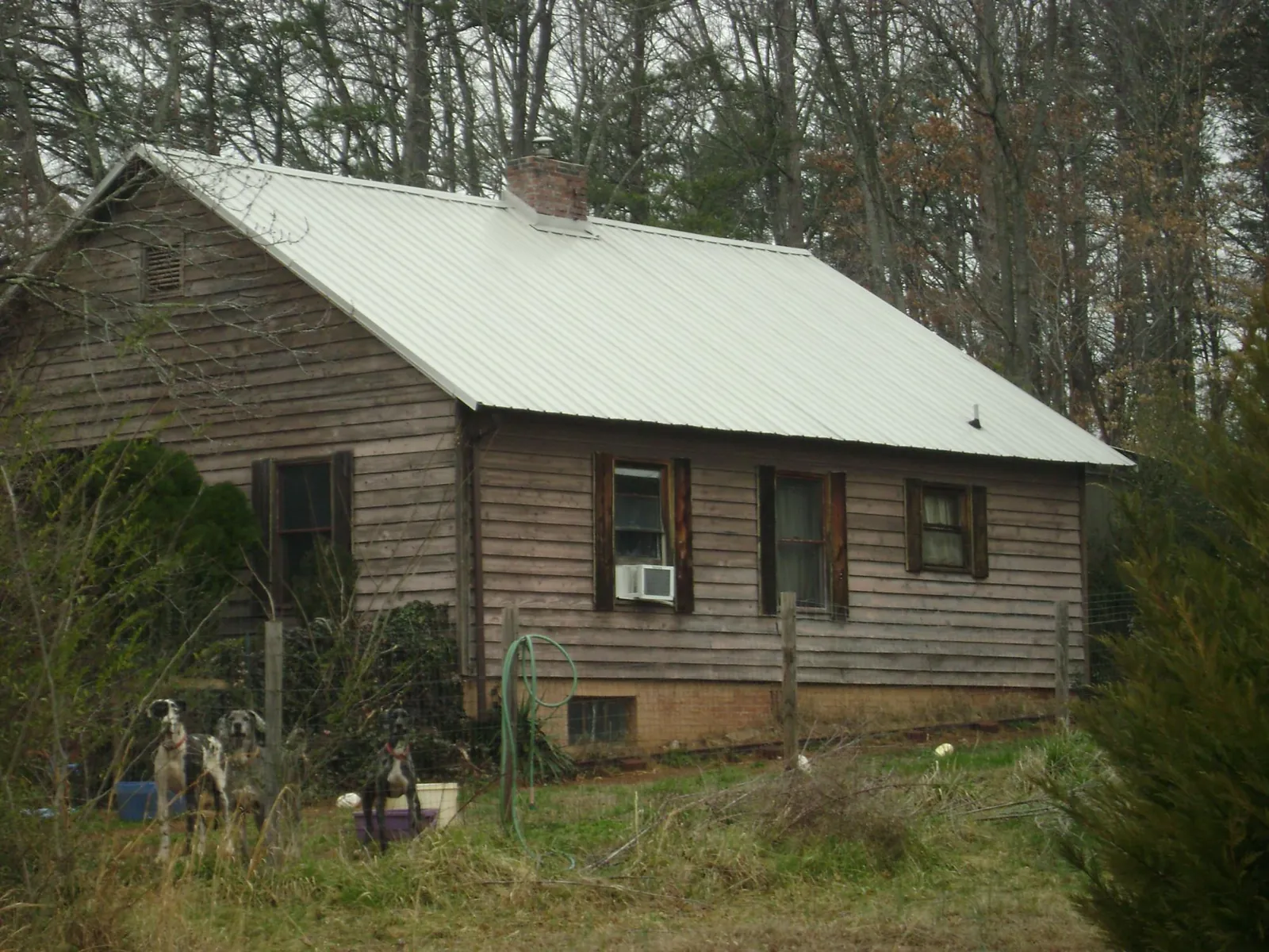 White metal roof on an old wood sided farmhouse, from a Metal Roof Installation job in Frisco